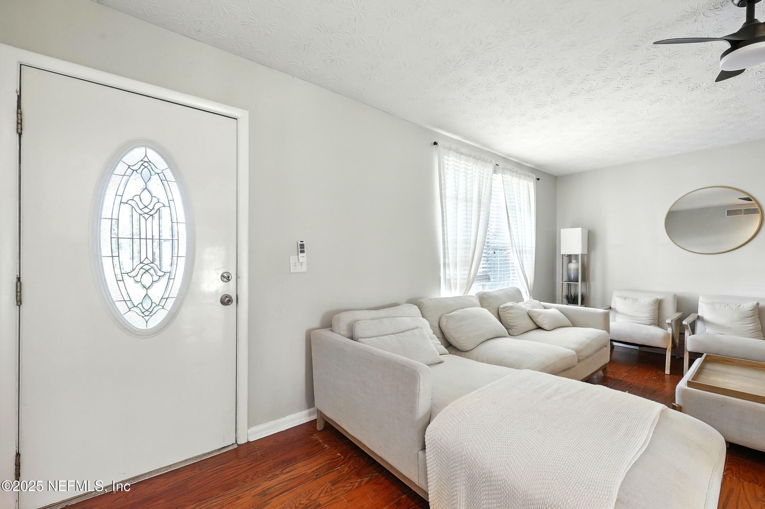 11599 Lake Ride Drive Jacksonville, FL 32223 - Photo 6 of 38 a living room with furniture a window and a mirror