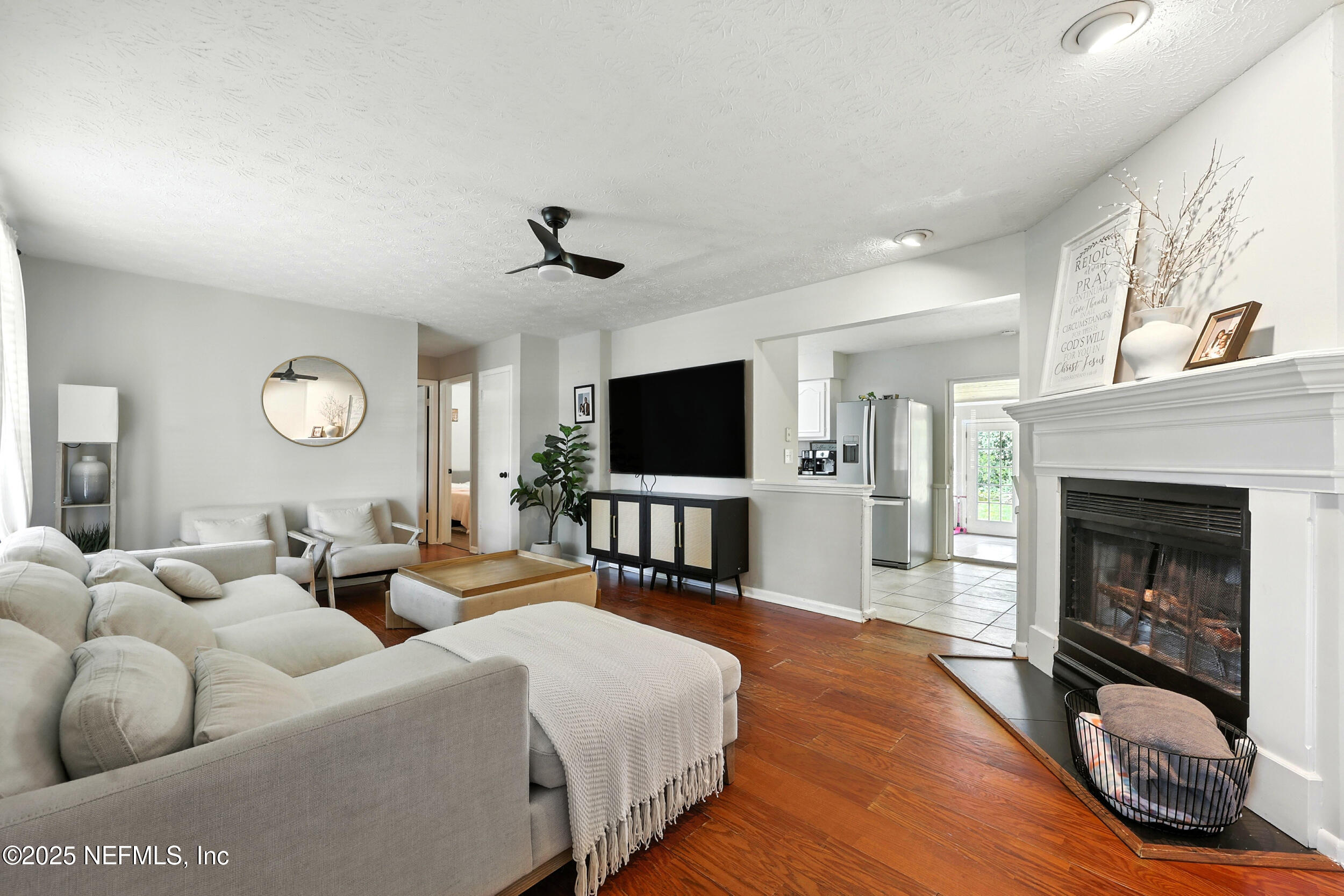 11599 Lake Ride Drive Jacksonville, FL 32223 - Photo 7 of 38 a living room with furniture a fireplace and a flat screen tv