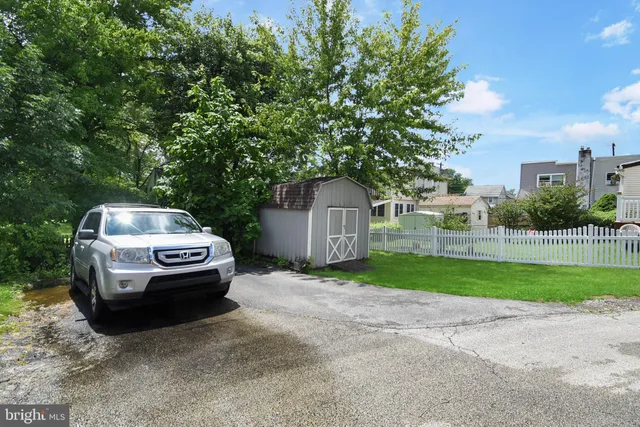 a car parked in front of a house with a small yard