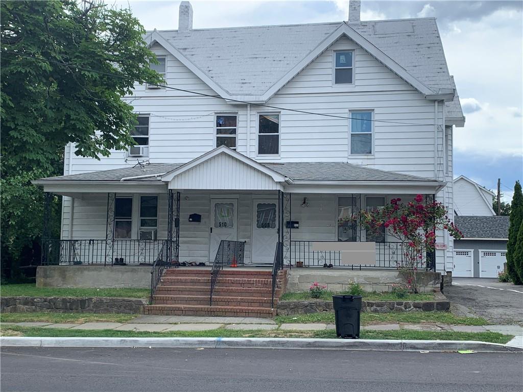 a front view of a house with a garden and plants