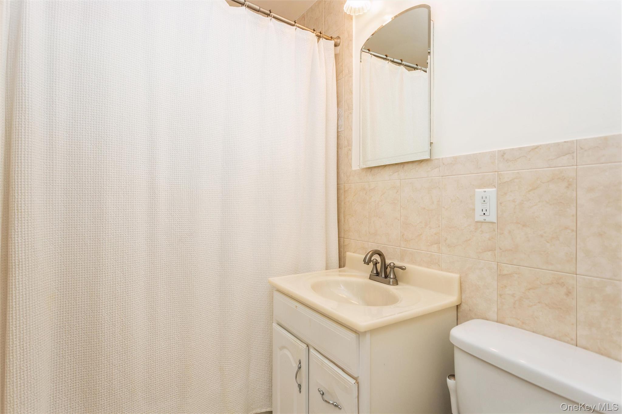 61 Manchester Road, Unit A21 Eastchester, NY 10709 - Photo 12 of 25 a bathroom with a sink a toilet and vanity