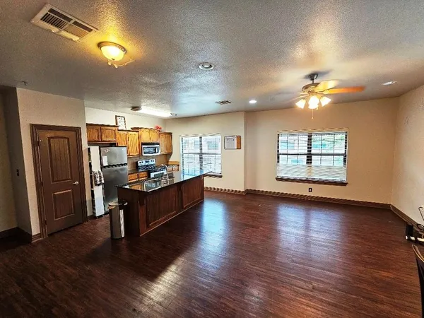 a kitchen with stainless steel appliances wooden floors and wooden cabinets