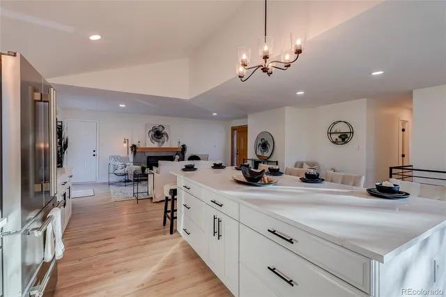 a kitchen with kitchen island a sink and a stove with wooden floor