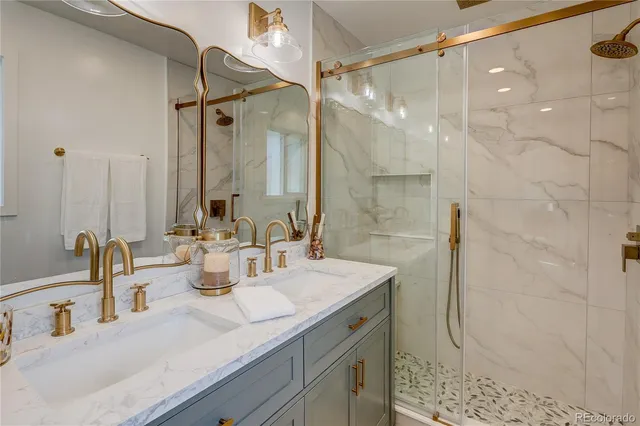 a bathroom with a double vanity sink mirror and shower