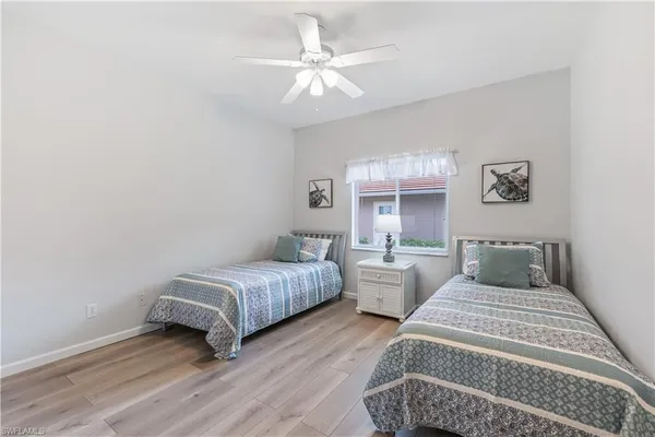 a bedroom with two beds and a chandelier