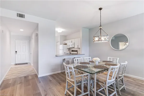 a view of a dining room with furniture a chandelier and wooden floor