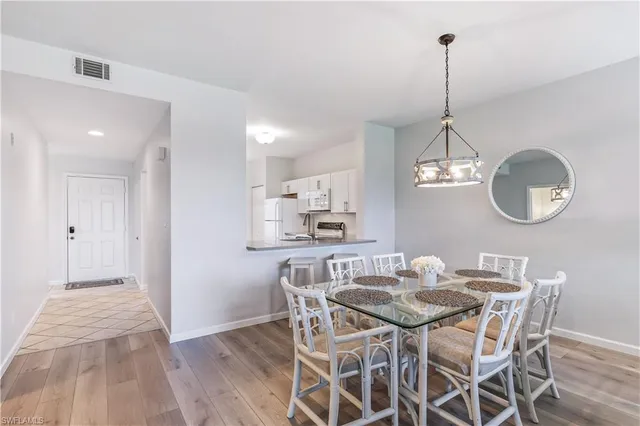 a view of a dining room with furniture a chandelier and wooden floor
