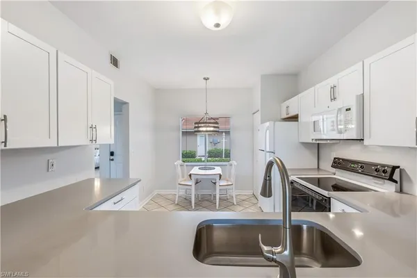 a kitchen with a sink a counter and cabinets