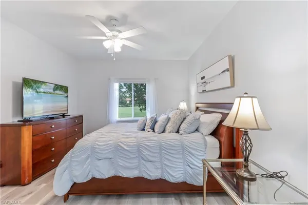 a bedroom with a large bed and a flat tv screen on dresser