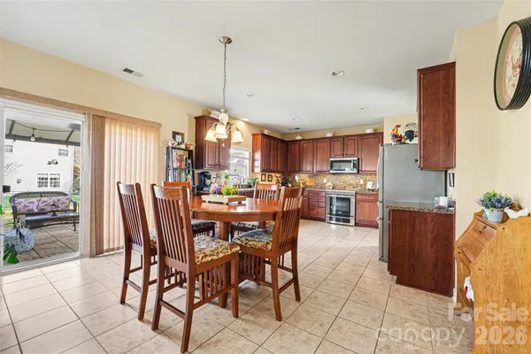 a view of a dining room and livingroom with furniture wooden floor a chandelier