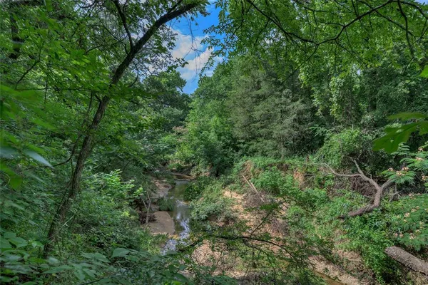 an aerial view of residential house with outdoor space and trees all around