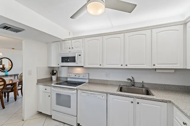 a kitchen with granite countertop a sink a stove and cabinets