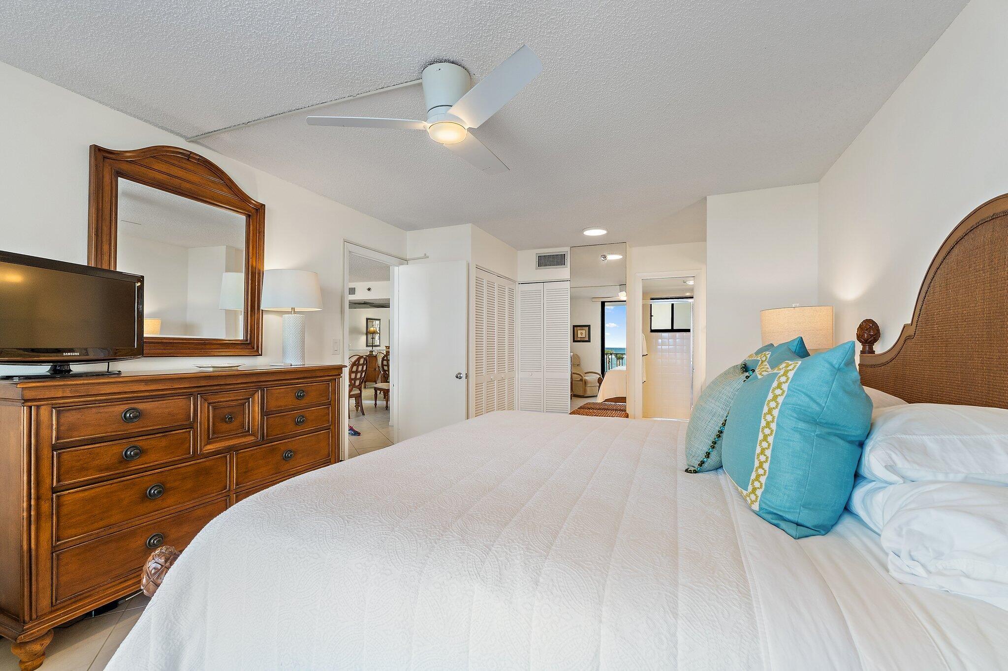 100 Ocean Trail Way, Unit 405 Jupiter, FL 33477 - Photo 23 of 38 a bedroom with a large bed and a flat tv screen on dresser