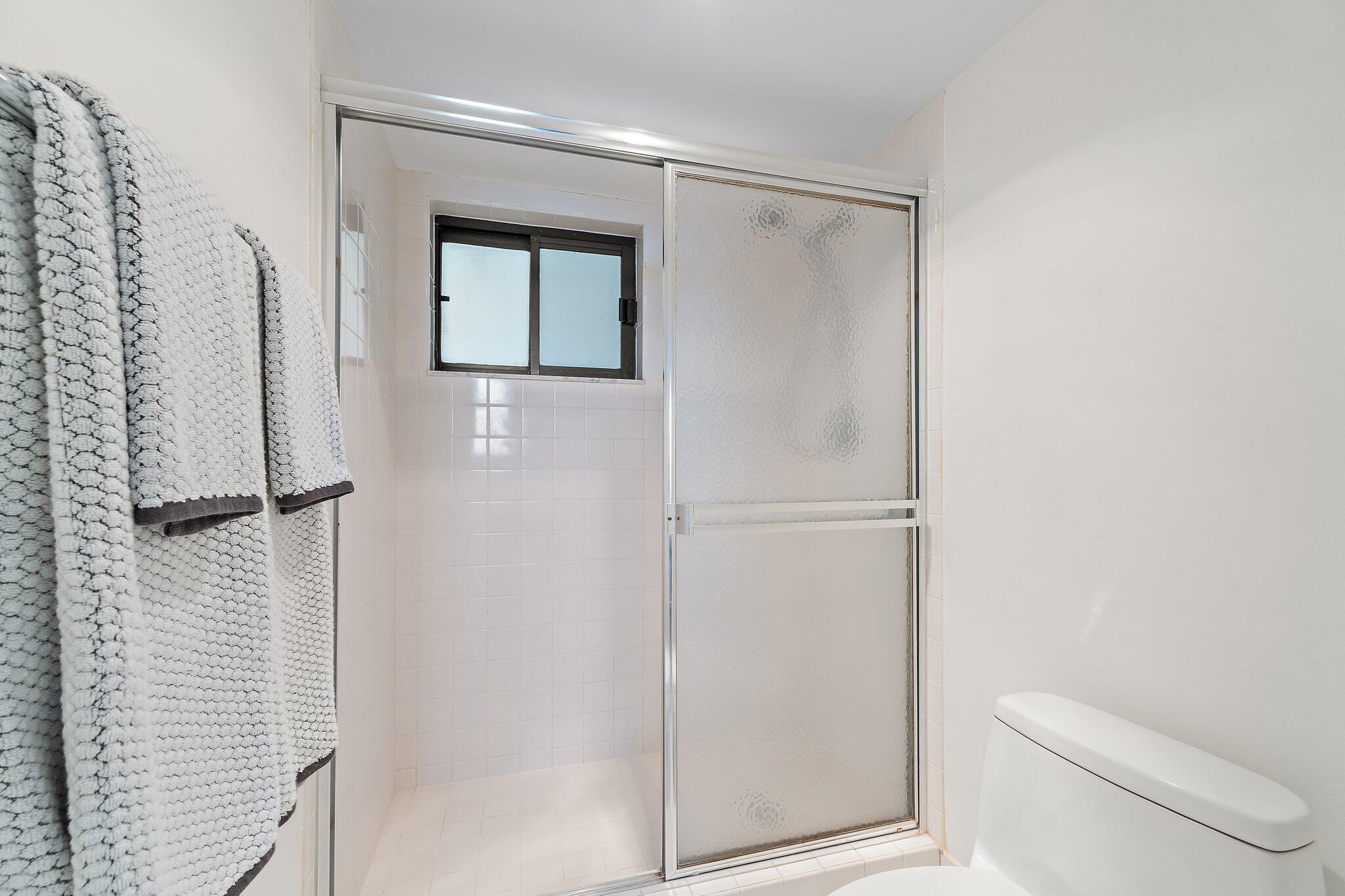 100 Ocean Trail Way, Unit 405 Jupiter, FL 33477 - Photo 26 of 38 a bathroom with a shower and a toilet