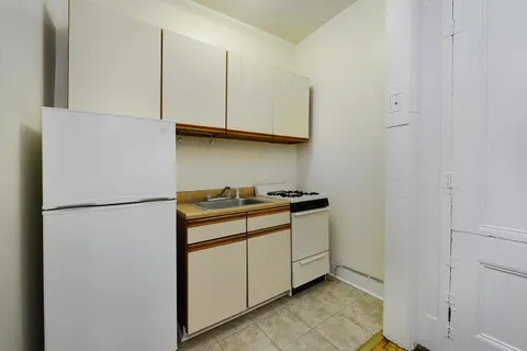 a white refrigerator freezer and a stove sitting inside of a kitchen