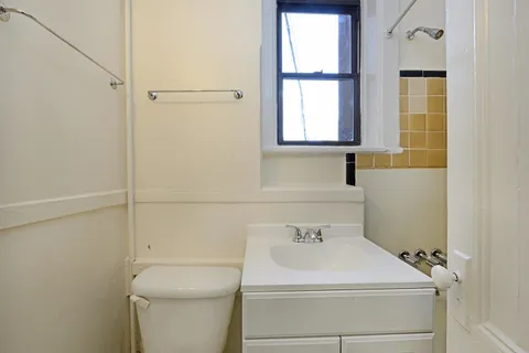 a bathroom with a sink a toilet and window