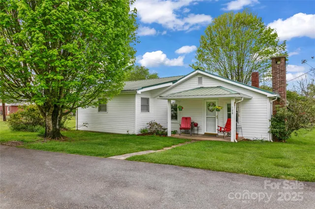 a view of a house with a yard and potted plants