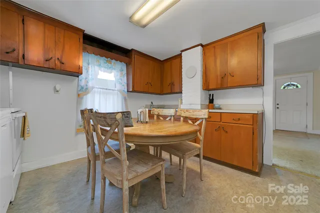 a room with a table chairs and a refrigerator