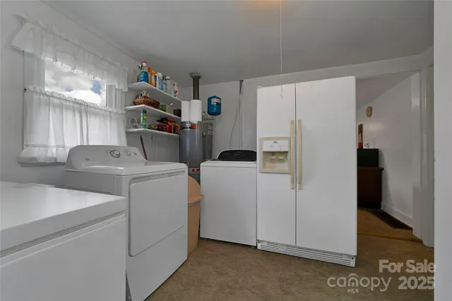 a view of storage and utility room with refrigerator and washer