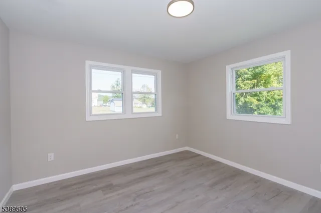 an empty room with kitchen and wooden floor