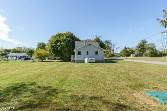 a front view of house with yard and trees in the background
