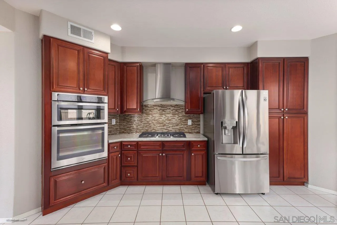3707 Via Del Rancho Oceanside, CA 92056 - Photo 17 of 45 a kitchen with stainless steel appliances granite countertop a refrigerator and a stove top oven