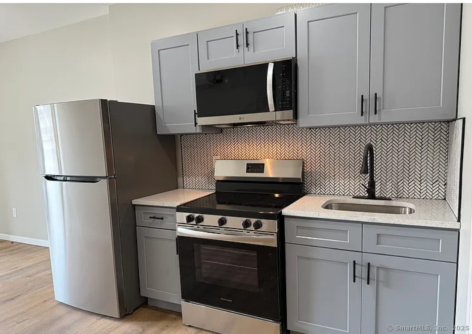 61 Field Street, Unit 211 Waterbury, CT 06702 - Photo 1 of 11 a kitchen with stainless steel appliances a stove microwave and refrigerator