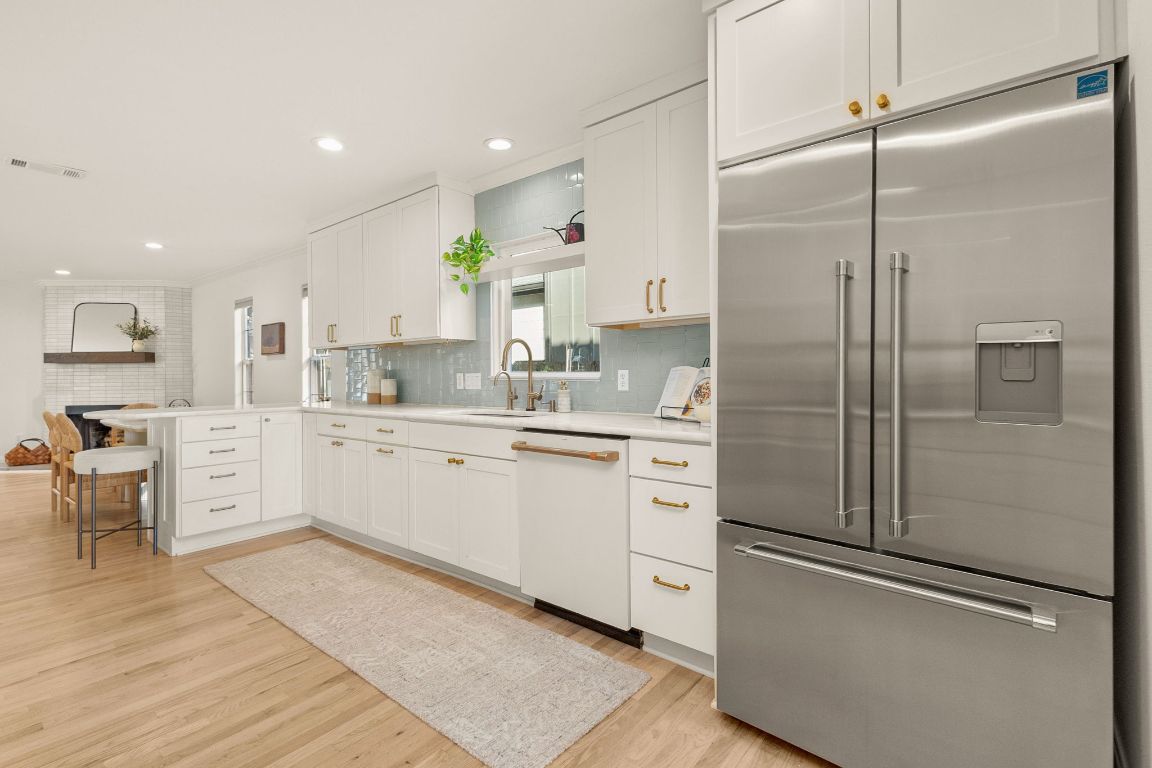 4312 Rosedale Avenue Austin, TX 78756 - Photo 16 of 40 Kitchen featuring stainless steel built in fridge, white cabinets, a peninsula, dishwasher, and backsplash