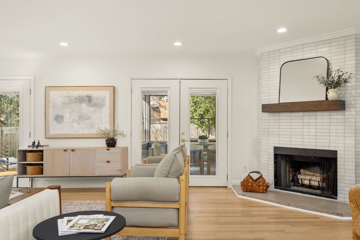 4312 Rosedale Avenue Austin, TX 78756 - Photo 20 of 40 Living area featuring ornamental molding, light wood-type flooring, recessed lighting, a brick fireplace, and french doors