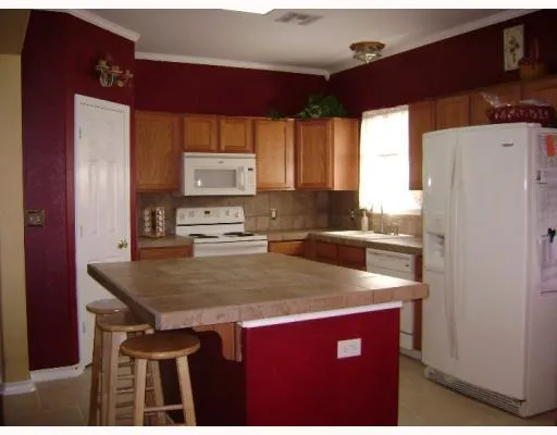 a kitchen with stainless steel appliances a table chairs and a refrigerator
