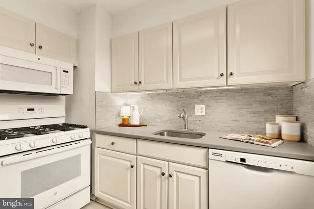 a kitchen with stainless steel appliances granite countertop white cabinets sink and dishwasher