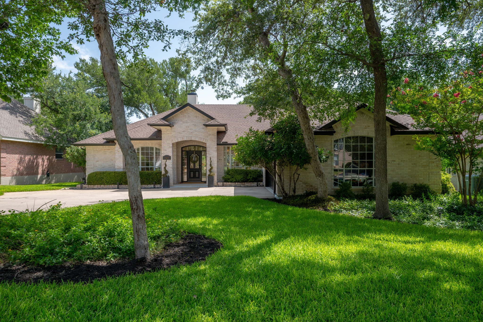 30115 Sawgrass Trail Georgetown, TX 78628 - Photo 23 of 37 A graceful brick home featuring arched windows and mature shade trees frames the inviting entry.