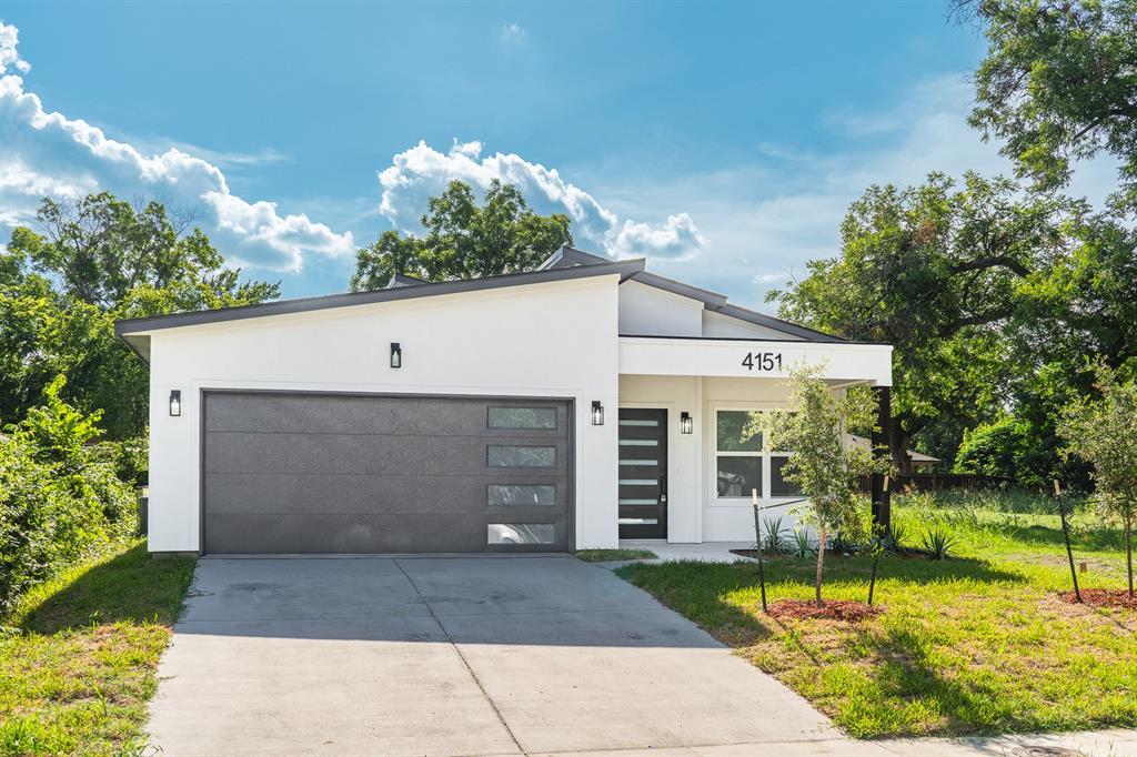 a view of a white house with a yard and potted plants