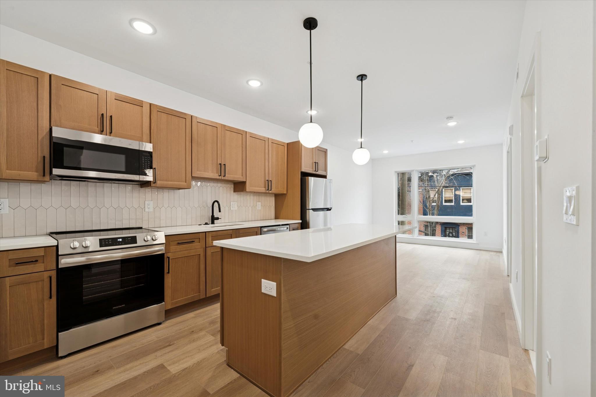 a kitchen with stainless steel appliances granite countertop a stove top oven a sink and a microwave