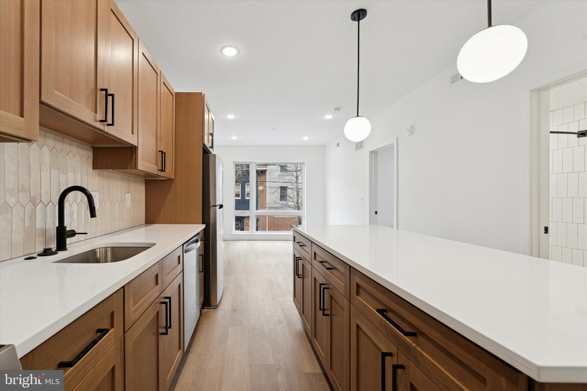 754 South 4th Street, Unit 405 Philadelphia, PA 19147 - Photo 2 of 18 a kitchen with stainless steel appliances granite countertop a sink a stove and a wooden floors