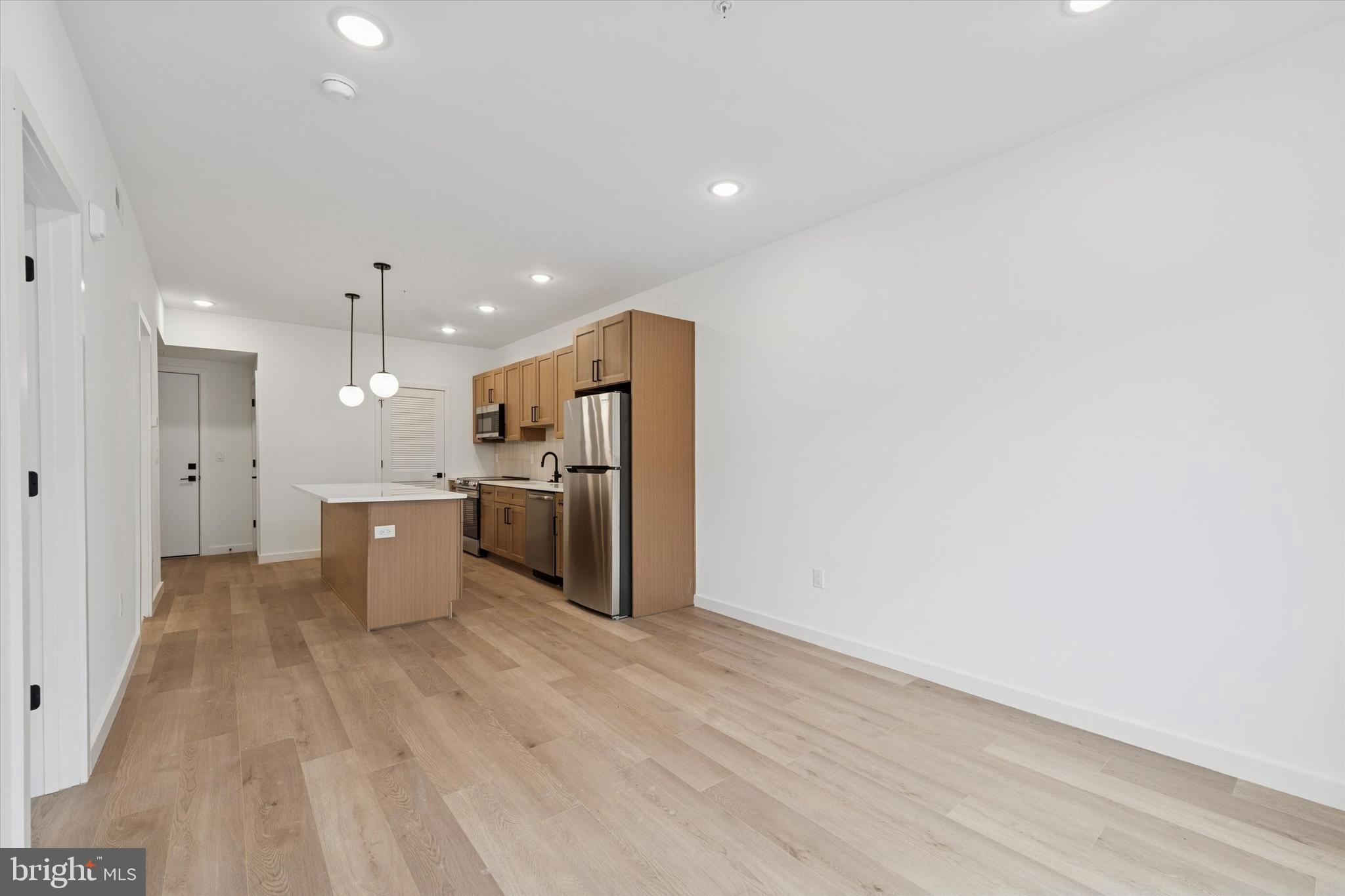 754 South 4th Street, Unit 405 Philadelphia, PA 19147 - Photo 3 of 18 a kitchen with stainless steel appliances kitchen island wooden cabinets and refrigerator
