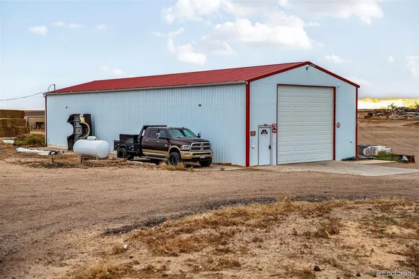 a backyard of a house with barbeque oven table and chairs