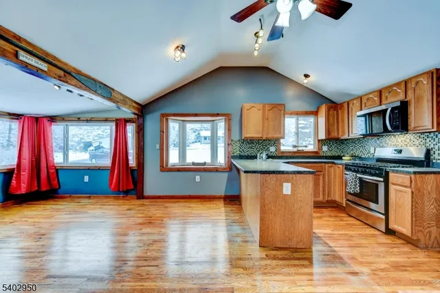 a kitchen with stainless steel appliances granite countertop a stove a sink and a refrigerator