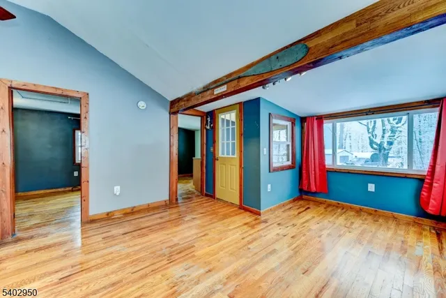 a view of a big room with wooden floor and windows
