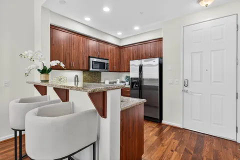 a kitchen with stainless steel appliances granite countertop a refrigerator sink and stove