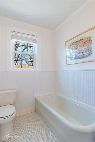 a white bath tub sitting next to a toilet