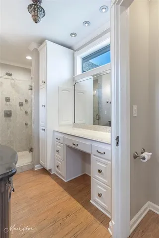 a bathroom with a sink a mirror a vanity and a shower