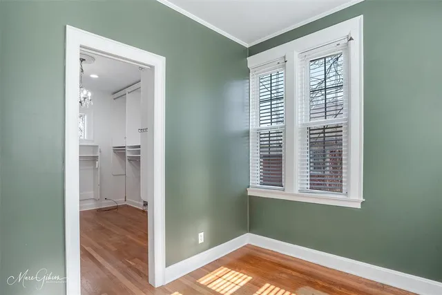 a view of hallway with window and wooden floor