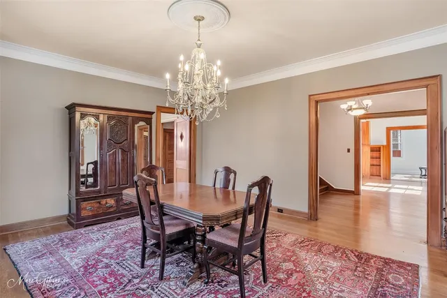a view of a dining room with furniture a chandelier and wooden floor