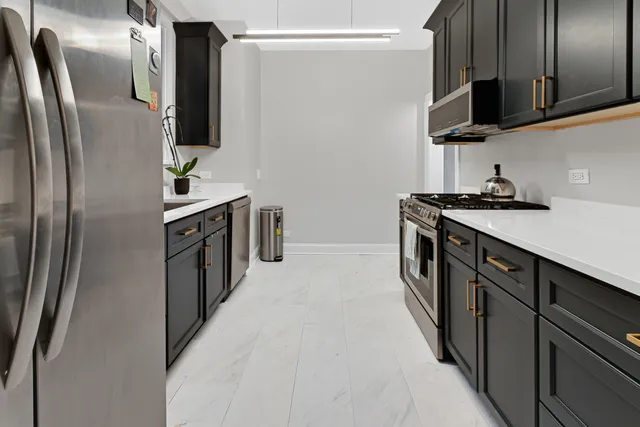 a kitchen with stainless steel appliances granite countertop a refrigerator a sink a stove and oven