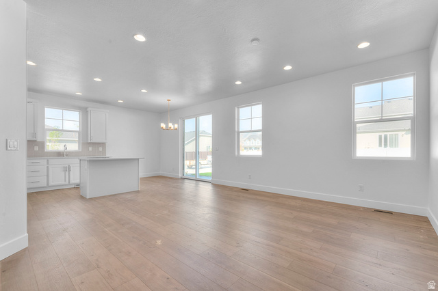 5644 Ibis Road Tooele, UT 84074 - Photo 12 of 19 Open-concept living space featuring wood-finish flooring, recessed lighting, and ample natural light from multiple windows and a sliding glass door