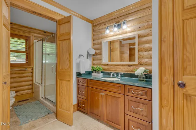 a bathroom with a granite countertop sink a toilet and shower