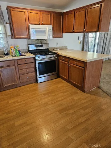 a kitchen with stainless steel appliances granite countertop a sink stove and cabinets
