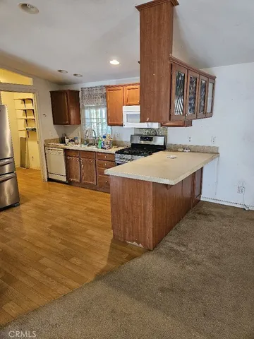 a large kitchen with stainless steel appliances a stove a sink a refrigerator and a microwave