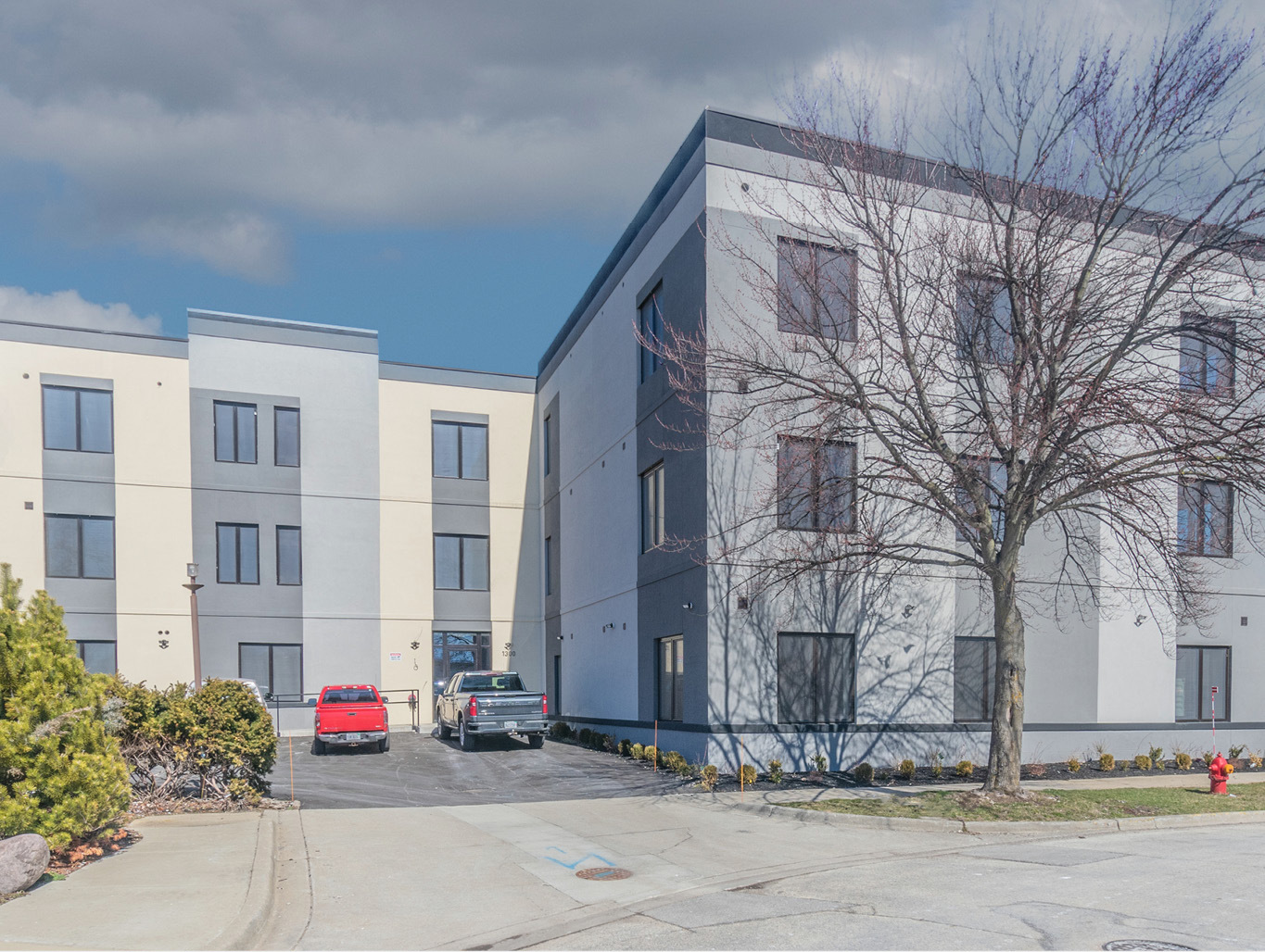 a front view of multi story residential apartment building with yard and traffic signal